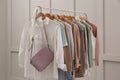 Rack with stylish women`s clothes near light wall Royalty Free Stock Photo