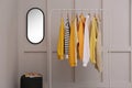 Rack with stylish women`s clothes near light wall Royalty Free Stock Photo