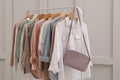 Rack with stylish women`s clothes near light wall Royalty Free Stock Photo