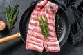 Rack of uncooked raw pork spare ribs seasoned with spices in a pan. Black background. Top view Royalty Free Stock Photo