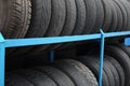 Rack with variety of car tires in automobile store. Many black tires. Tire stack background Royalty Free Stock Photo