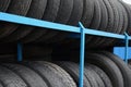 Rack with variety of car tires in automobile store. Many black tires. Tire stack background Royalty Free Stock Photo