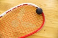 Racket and squash ball lie on the parquet floor. Top view Royalty Free Stock Photo