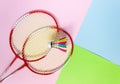 Rackets and a badminton shuttlecock on a multicolored background, top view. Sports, summer outdoor activities