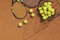 Rackets and basket with tennis balls on clay court Royalty Free Stock Photo