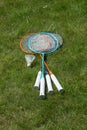 Rackets and a shuttlecock for badminton on the grass.