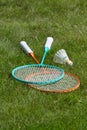 Rackets and a shuttlecock for badminton on the grass.