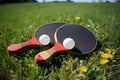 Rackets for table tennis placed on vibrant grass, awaiting competitors