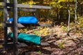 Wooden racks of colorful kayaks in the sunny lush autumn woods