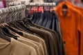 Racks of sweaters and shirts hanging in a store