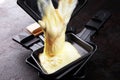 Raclette cheese melted served in individual raclette skillets
