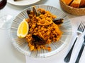 Racy seafood paella with mussels, squid rings and lemon Royalty Free Stock Photo