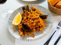Racy seafood paella with mussels, squid rings and lemon Royalty Free Stock Photo