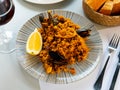 Racy seafood paella with mussels, squid rings and lemon