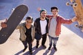 A rad day at the park. A portrait of three skater friends holding up their boards.