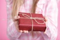 Rad giftbox in female hands in pink background Royalty Free Stock Photo