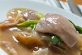 Rad Na, Famous Thai Chinese style wide rice noodle dish with tasty tender pork with thick gravy sauce. close up.