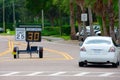 Radar speed limit indicator sign showing 30 proving a passing car is speeding as it drives down the road in a school zone Royalty Free Stock Photo