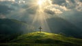 Radiant beam of sunlight breaking through clouds, illuminating a cross on a hill with lush green fields below Royalty Free Stock Photo