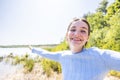 Radiant Freedom: Joyful Woman Embracing Nature's Beauty at a Forest Lake, Free Happy Woman Enjoying Nature on a Royalty Free Stock Photo