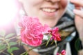 A radiant pink flower held by a smiling happy woman who appears to be cold. Royalty Free Stock Photo