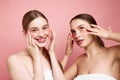 Radiant Rituals. Portrait of two young attractive girls applying under-eye moisturized patches. Girls embrace natural