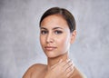 Radiant skin. An isolated portrait of a beautiful young woman touching her neck. Royalty Free Stock Photo