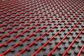 Radiant underfloor heating installation with red flexible tubing mounted on black insulation boards Royalty Free Stock Photo