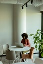 Radiant Woman Engaging in a Phone Conversation While Working at a Bright Cafe Royalty Free Stock Photo