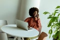 Radiant Woman Engaging in a Phone Conversation While Working at a Bright Cafe Royalty Free Stock Photo