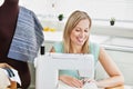 Radiant woman sewing clothes at home