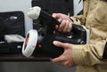 Radiation detector testing. Dosimetrist hands holding a handheld radiation isotope identifier, black boxes on a background