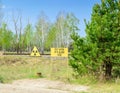 Radiation hazard sign in the red forest near the town of Pripyat. Chernobyl Exclusion Zone. Royalty Free Stock Photo