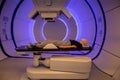 Radiation proton therapy. Brain cancer child patient lying on positioning bed with fixing mask on her head