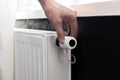 Radiator adjustment closeup. Man`s hand adjusting radiator temperature