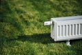 Radiator on green lawn, ecological heating concept