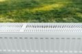 Radiator on green lawn, ecological heating concept