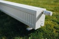 Radiator on green lawn, ecological heating concept