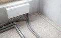 radiator with supplied heating pipes and electric cables laid in the corrugation in new apartment under construction