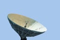 Radio antenna dish with snow inside on a blue background Royalty Free Stock Photo