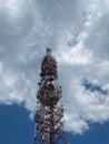 Radio cell tower with blue sky and clouds in background