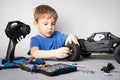 Radio controlled models: A little boy in a blue T-shirt is repairing his RC car buggy. Royalty Free Stock Photo