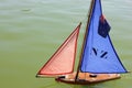 Radio-controlled yacht model, with red-blue sail and flag of New Zilandia