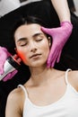 Radio frequency lifting with red light for young woman close-up. Dermatologist is doing radio frequency RF skin Royalty Free Stock Photo