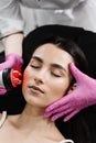Radio frequency lifting with red light for young woman close-up. Dermatologist is doing radio frequency RF skin Royalty Free Stock Photo