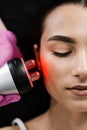 Radio frequency lifting with red light for young woman close-up. Dermatologist is doing radio frequency RF skin Royalty Free Stock Photo