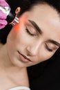 Radio frequency lifting with red light for young woman close-up. Dermatologist is doing radio frequency RF skin Royalty Free Stock Photo