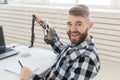 Radio host concept - Portrait of funny handsome bearded man sitting in front of microphone Royalty Free Stock Photo