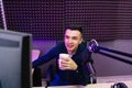 radio host drinking tea conducts a live broadcast in professional radio studio. Royalty Free Stock Photo