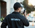 Radio, man and a security guard or safety officer outdoor on a city road for communication. Back of a person with a Royalty Free Stock Photo